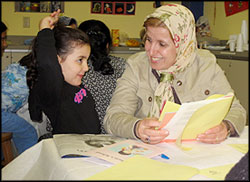 A photo of a woman reading to a young girl.
